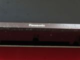 a panasonic monitor sitting on a red table