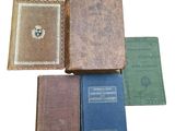 plusieurs vieux livres posés les uns sur les autres sur une surface blanche