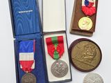 trois médailles et une médaille dans une boîte posée sur une table
