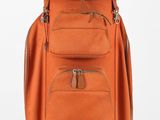 un sac à dos orange posé sur un support en bois