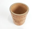 une tasse en bois posée sur une surface blanche