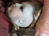 a doll being held by a person with a pair of scissors