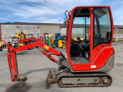 a small red excavator that is parked in a parking lot