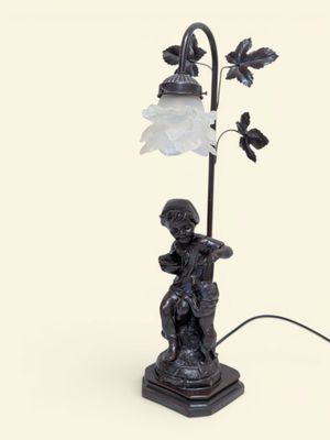 une image représentant la statue d'un garçon tenant une lampe