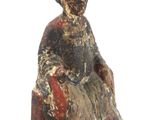 statue of a woman sitting on a chair with a hat on