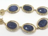 a close up of a bracelet with blue stones on it