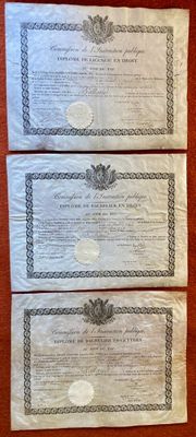trois certificats posés sur une table recouverte d'une nappe rouge