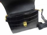 a black purse that is sitting on a white table