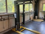 a picture of a garage with a fork lift in the middle of the floor