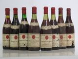 six bottles of wine are lined up in a row on a table