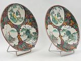 pair of chinese plates with figures on them on a stand