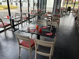 de nombreuses tables et chaises dans un restaurant doté d'une grande baie vitrée