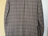 the jacket is hanging on a hanger on the wall