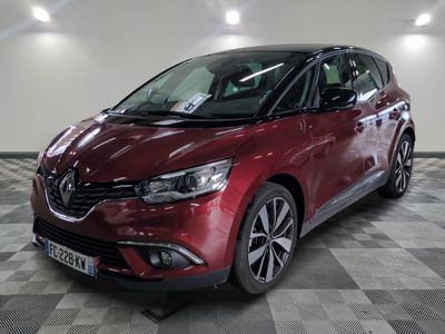 la voiture rouge est garée sur un sol en damier dans le garage