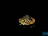 a close up of a yellow and black diamond on a black surface
