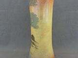 a vase with a painting on it sitting on a table