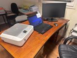 un ordinateur portable et une imprimante posés sur un bureau, devant un écran d'ordinateur