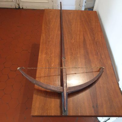 un arc et une flèche posés sur une table en bois dans une pièce