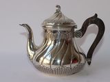 a silver tea pot on a white table
