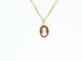 un collier plaqué or orné d'un pendentif en pierre rouge et blanche