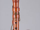 an old wooden pipe with a metal holder and a cup on a table