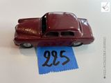 une petite voiture rouge posée sur une table, avec une étiquette de prix