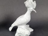 white porcelain figurine of a bird sitting on a branch