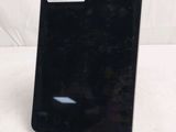 a close up of a cell phone on a stand on a white surface