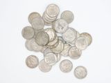 une pile de pièces d'argent sur une surface blanche