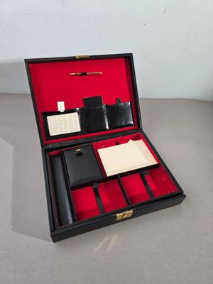 un étui noir avec une doublure rouge et un bloc-notes