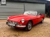 a red convertible car parked in front of a garage