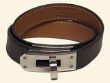 une ceinture en cuir noir avec une boucle argentée sur fond blanc