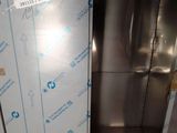 a stainless steel elevator with a glass door in a room