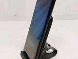 a close up of a cell phone on a stand on a white surface