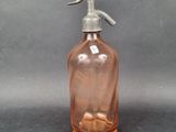a pink glass bottle with a metal sprayer on it