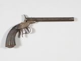 un vieux pistolet avec une poignée en bois sur une surface blanche