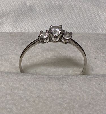 l'image d'une bague en diamant posée sur un tissu blanc