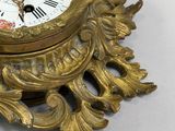 a gold clock that is sitting on a white table