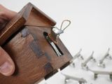 a person holding a small wooden box with a key in it