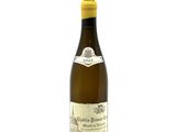 the bottle of white wine is sitting on a white surface