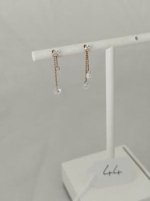 a pair of earrings on a white stand with a white background