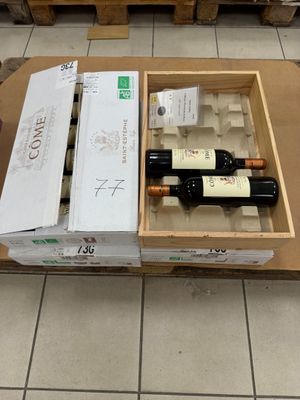 des bouteilles de vin dans un carton posé sur une table dans un magasin