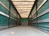 un long couloir avec un mur vert et une porte