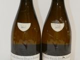 deux bouteilles de vin blanc posées sur une table blanche