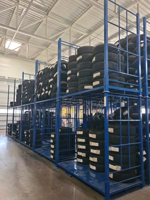 a lot of tires stacked on a rack in a warehouse