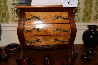 une petite commode sur laquelle est posée une horloge