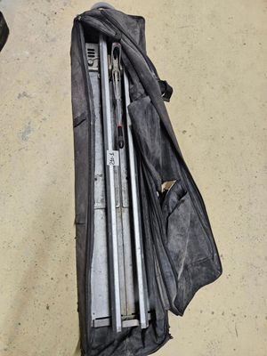 un sac posé par terre, contenant quelques outils