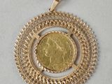 un gros plan d'une pièce d'or dans un pendentif circulaire