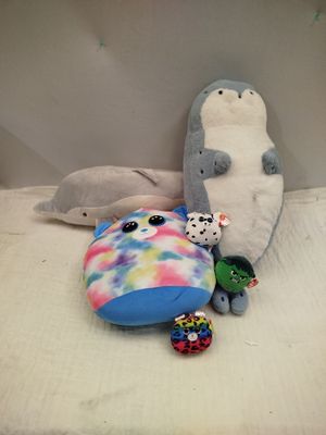 plusieurs peluches posées sur un lit avec un oreiller