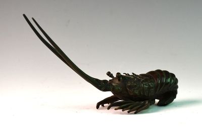 statue d'un homard posée sur une surface blanche, avec un fond blanc